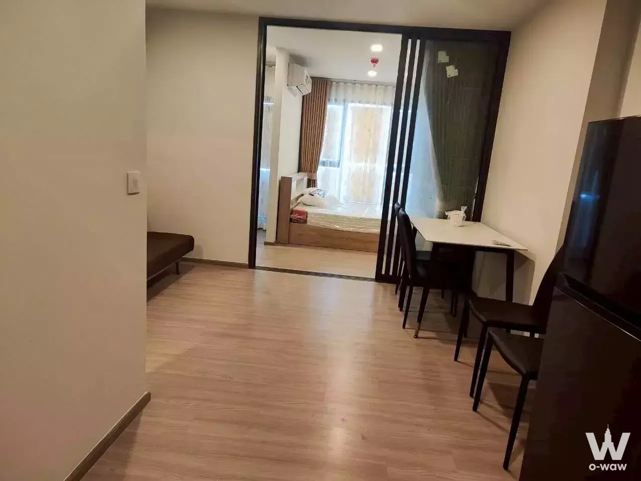 Aspire Sukhumvit-Rama 4 studio with wood floors, dining set, and bedroom visible through sliding doors
