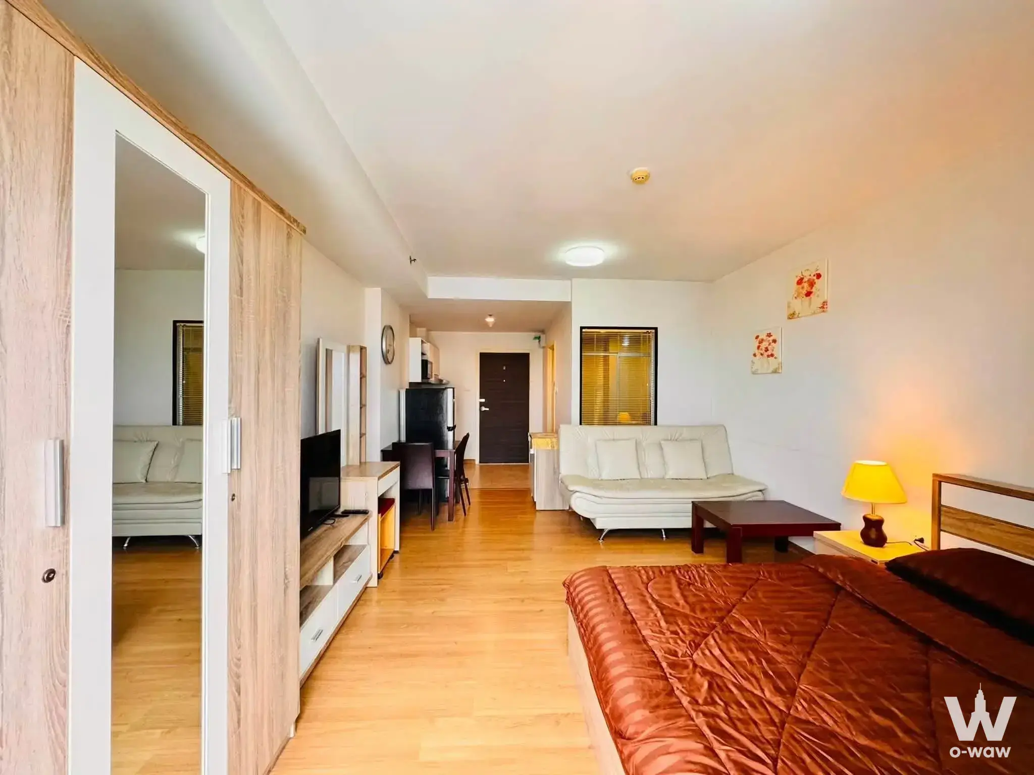 Fully furnished studio apartment in Supalai Mare Pattaya with queen bed, mirrored wardrobe, and open-plan layout