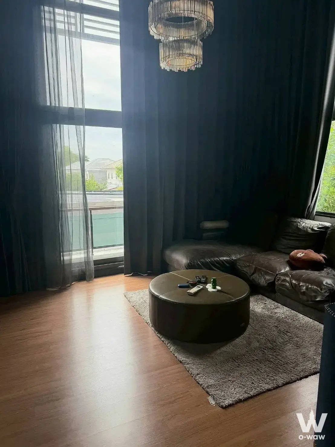 Moody 4-bed house living room in Passorn Songprapa with brown leather sectional and crystal chandelier