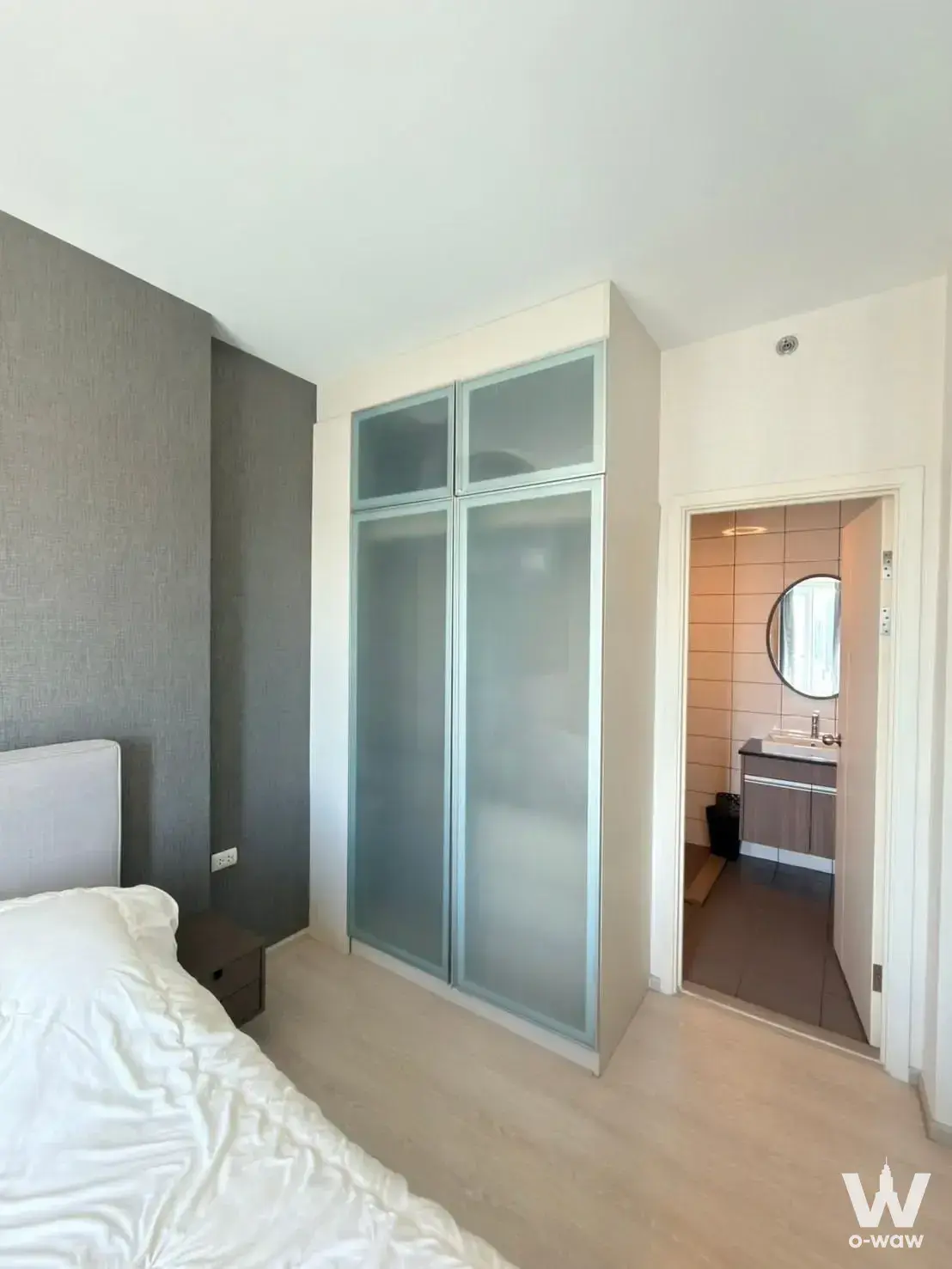 Bedroom in Chapter One Eco Ratchada-HuaiKhwang with floor-to-ceiling wardrobe, grey accent wall, and en-suite bathroom