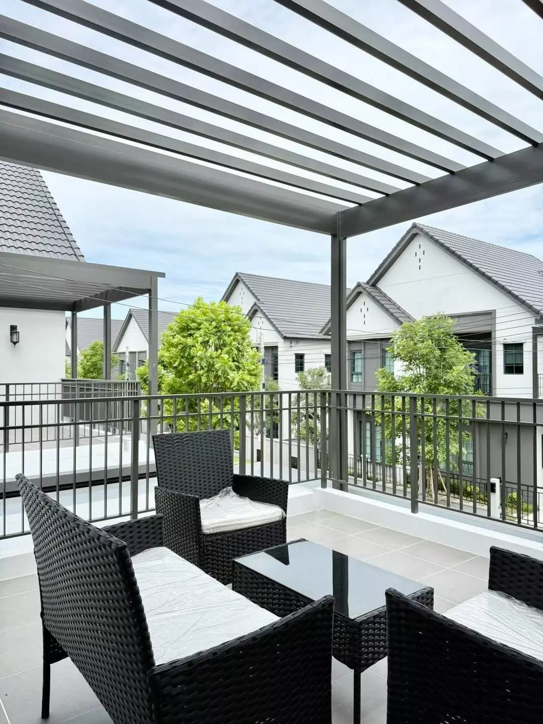 Balcony with pergola and wicker seating at 4-bed house for rent in Centro Bangna