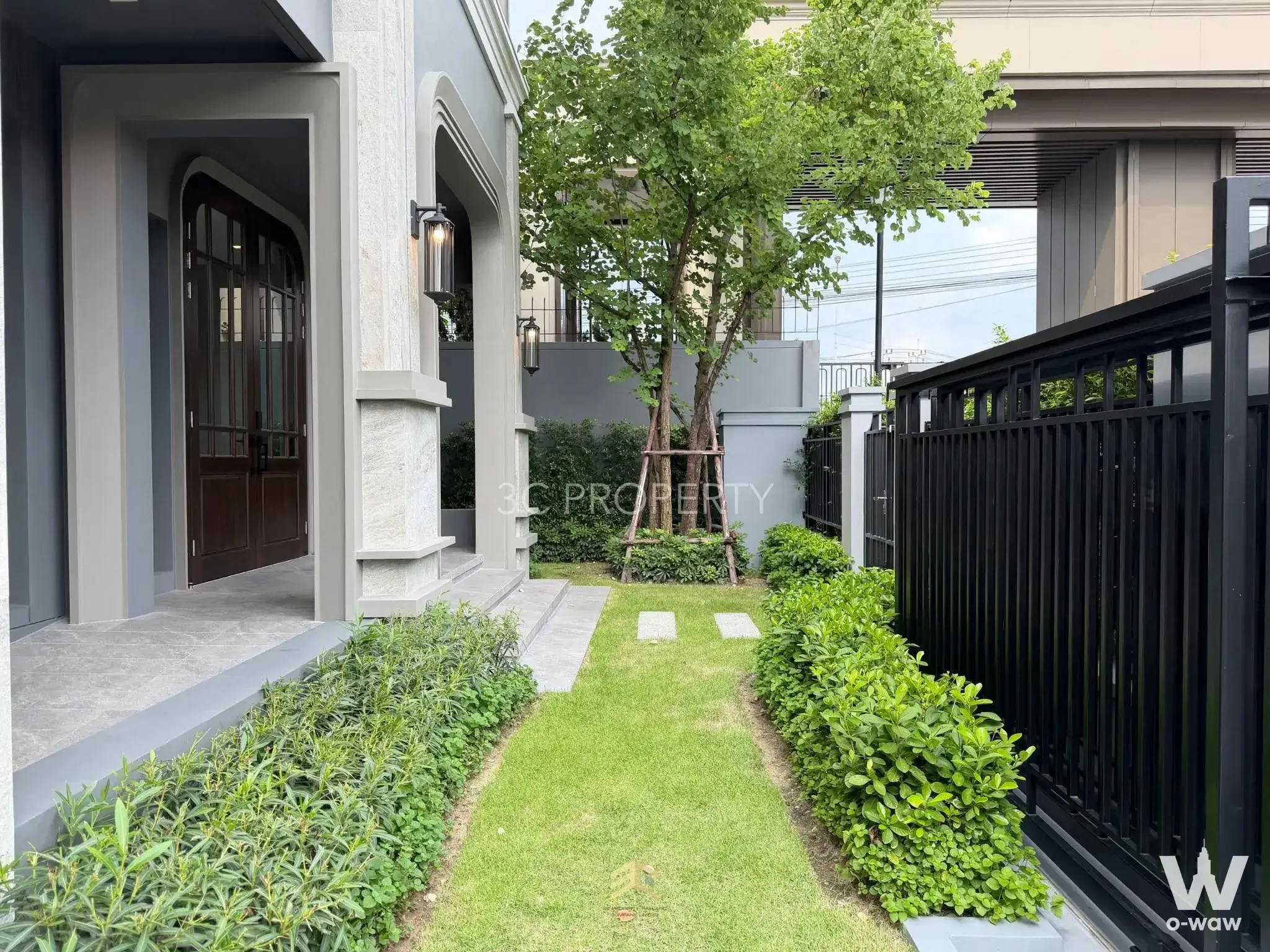 Front entrance with arched door and stone cladding at 4-bed house for sale in Grand Bangkok Boulevard