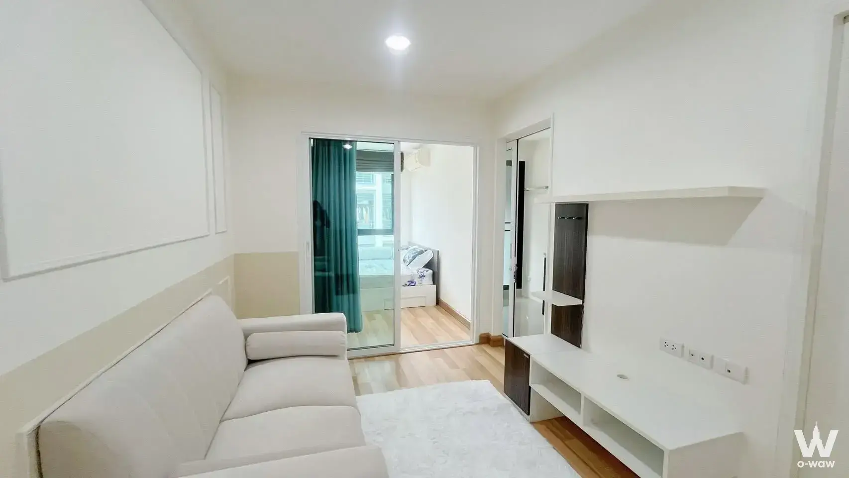 Cream sofa and media console in a 1-bed condo for sale at Apool Condo
