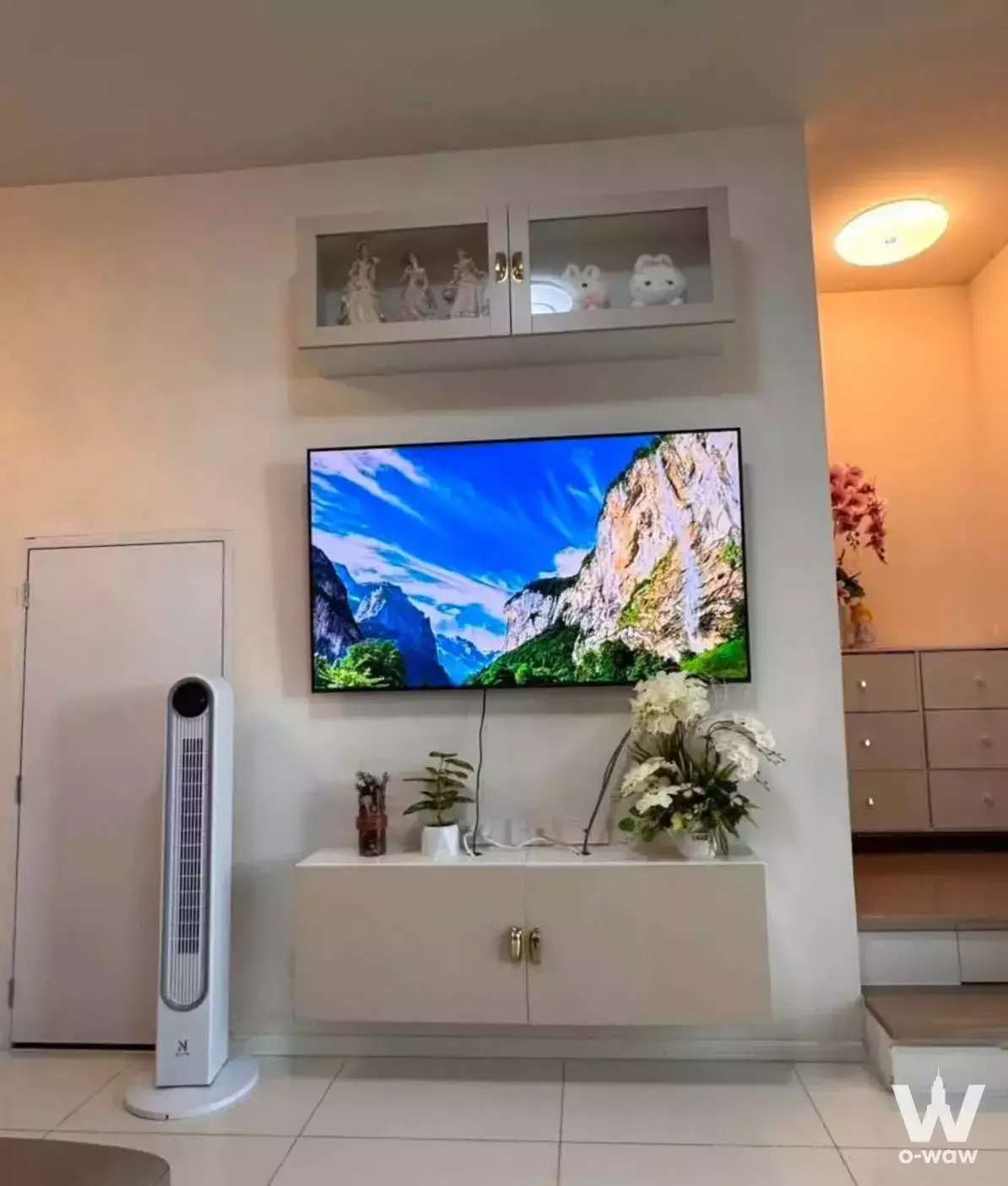 Altitude Kraf Bangna townhouse living room with white media console, gold accents, and raised wooden platform