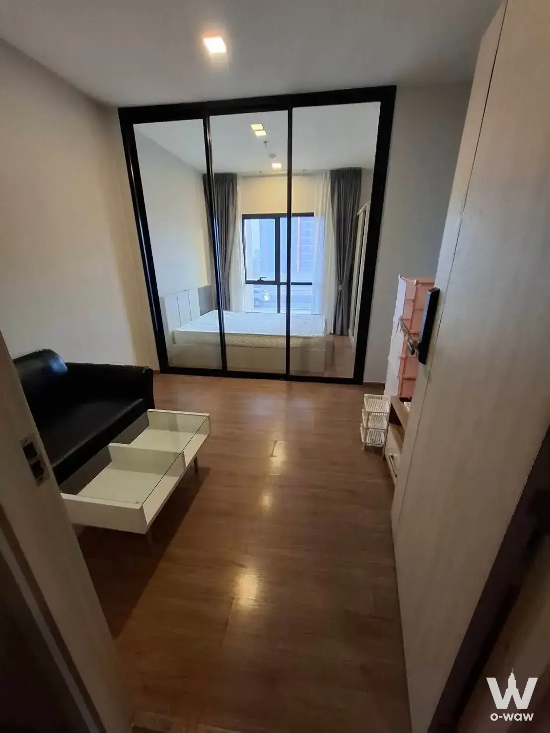 Studio apartment with dark wood flooring and glass partition in 1-bed Metris Rama 9 condo