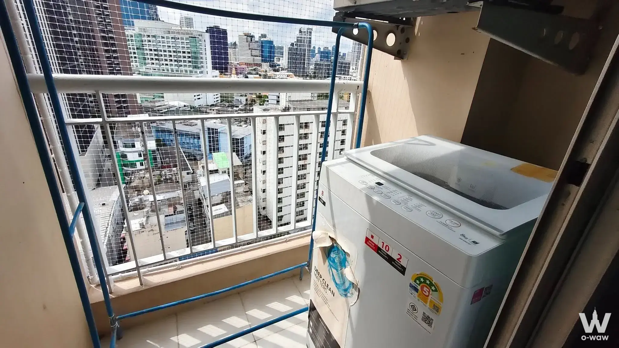 The balcony has a washing machine, drying rack and city view in a 1-bed Life @ Sukhumvit 65 condo