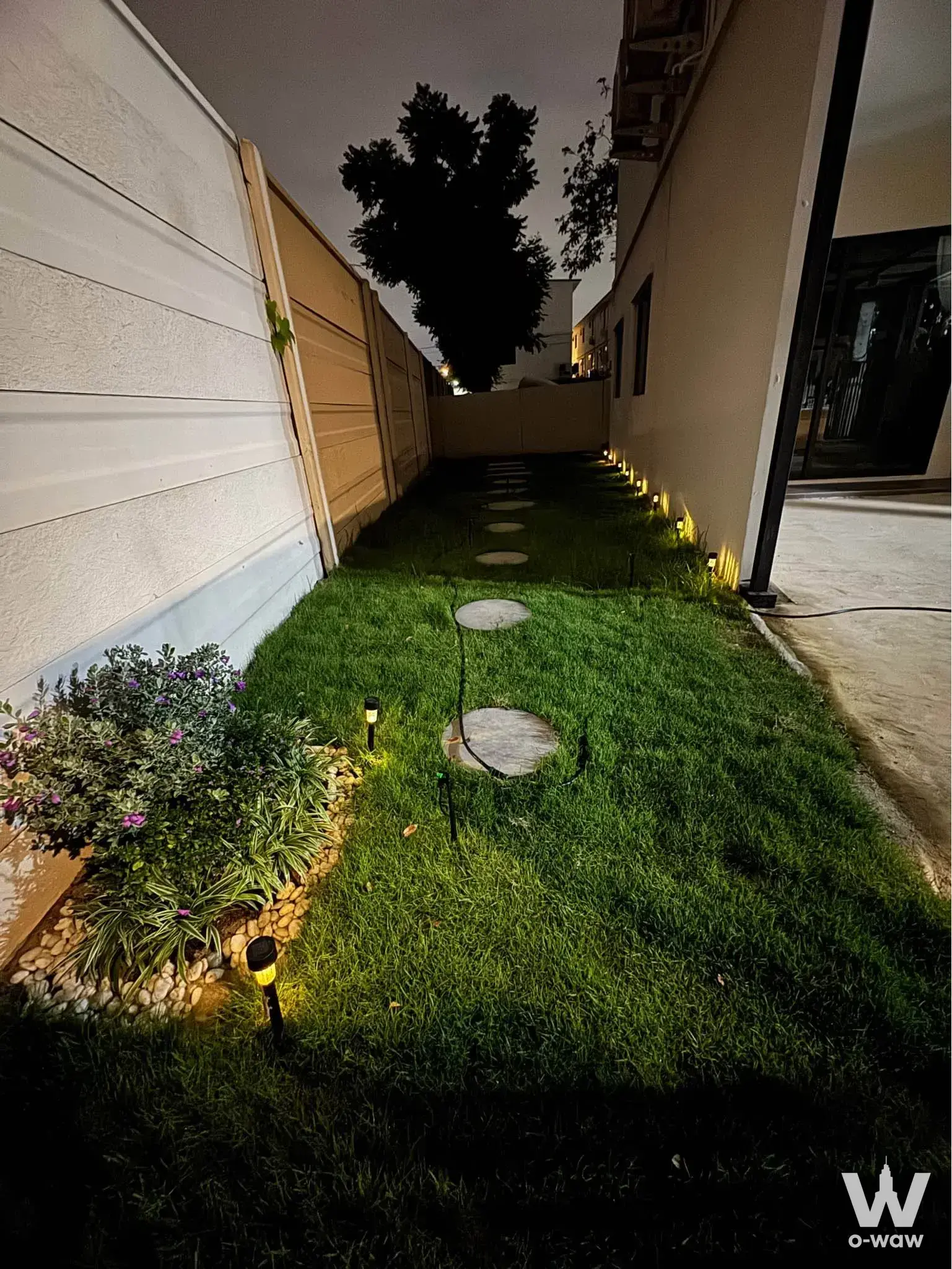 Landscaped side yard with stepping stones and solar lights at this 2-bed townhouse for rent in Altitude Kraf Bangna