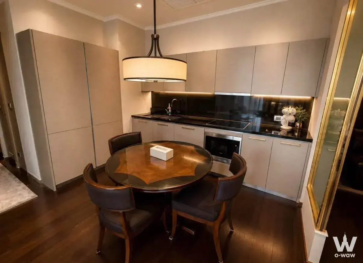 THE XXXIX by Sansiri 2-bed condo dining area with round table, leather chairs, and modern kitchenette