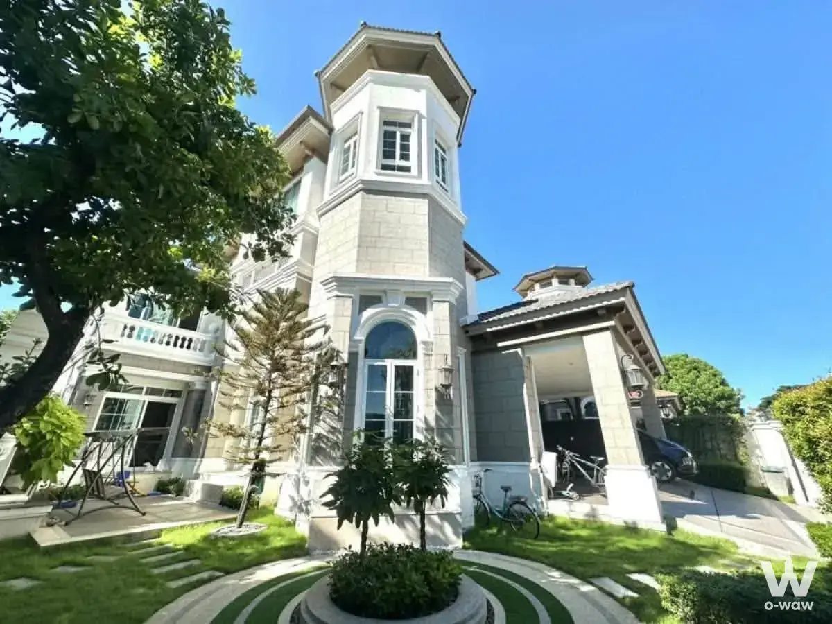 Three-story European-style villa with grey stone facade, octagonal turret, and manicured lawn for sale in LADAWAN RAMA2