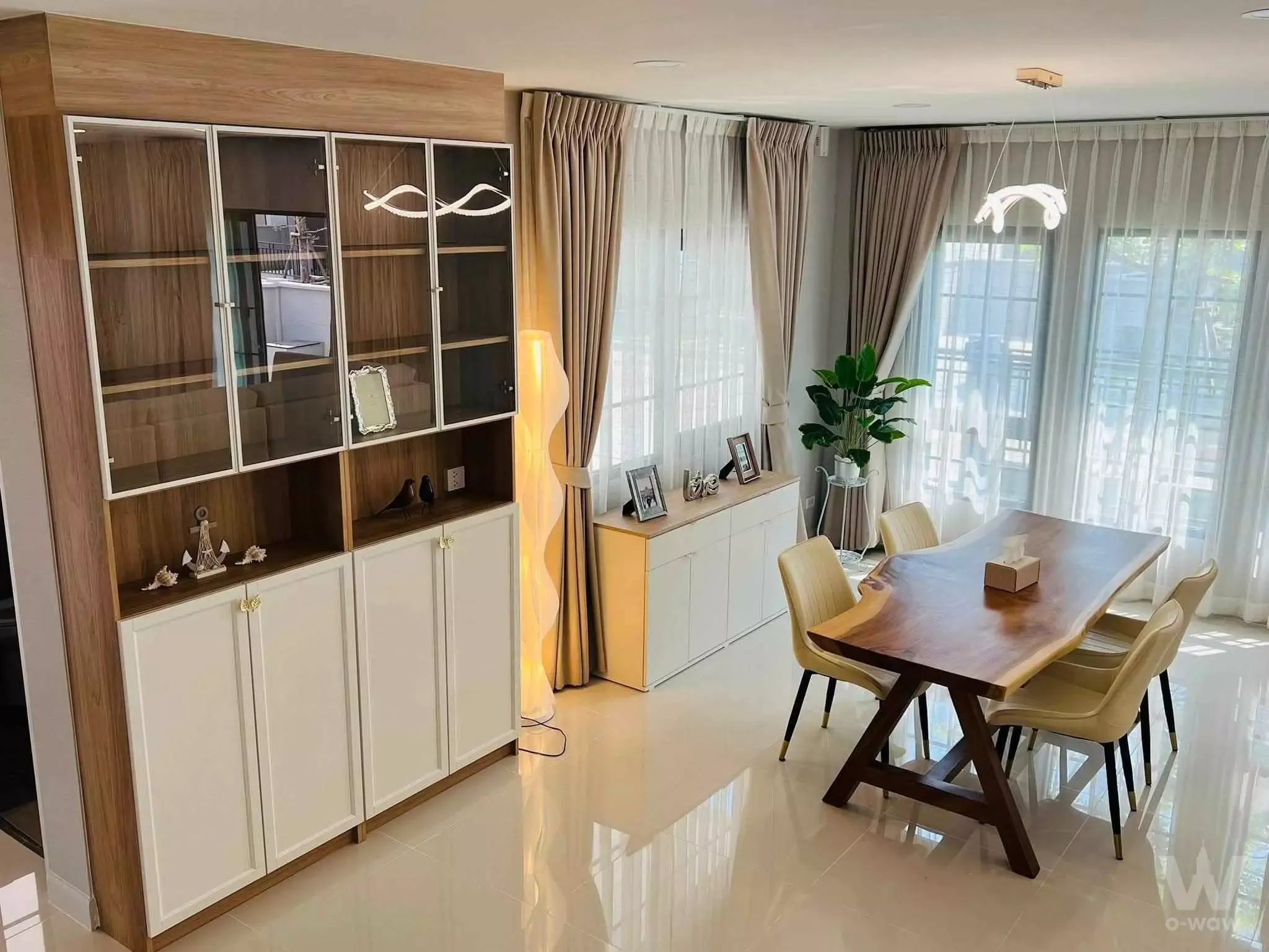 Dining room in Centro Bangna phase 2 with live-edge walnut table and floor-to-ceiling windows
