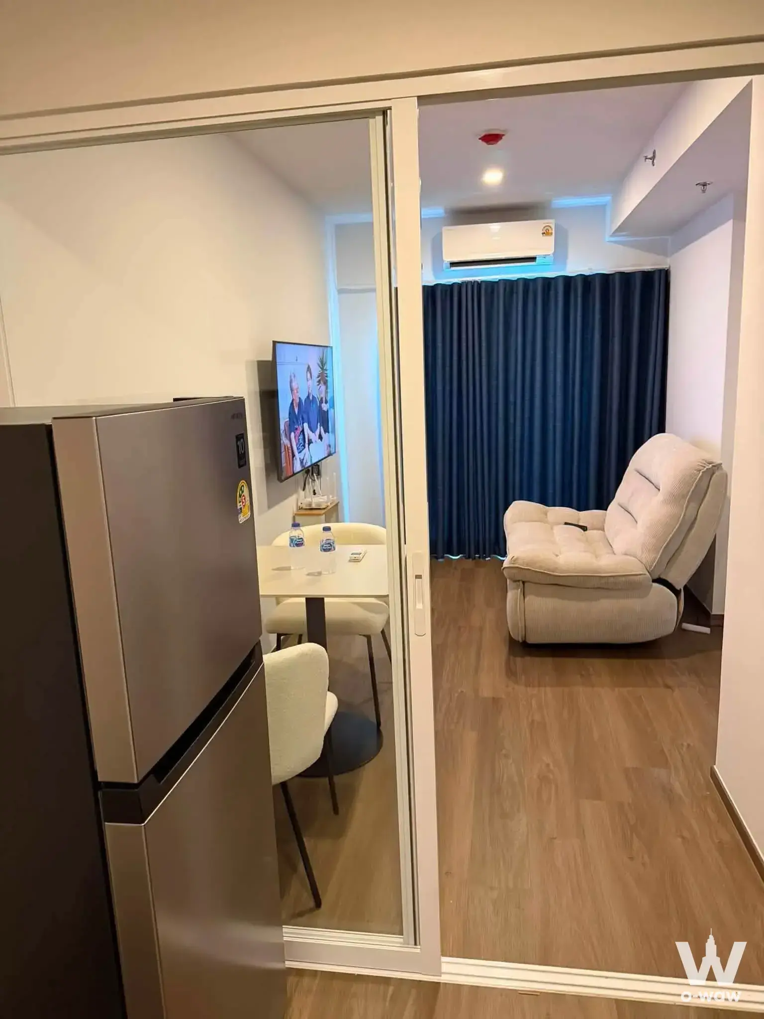 1-bed condo for rent in Place 168 Pinklao with beige recliner sofa and deep blue blackout curtains
