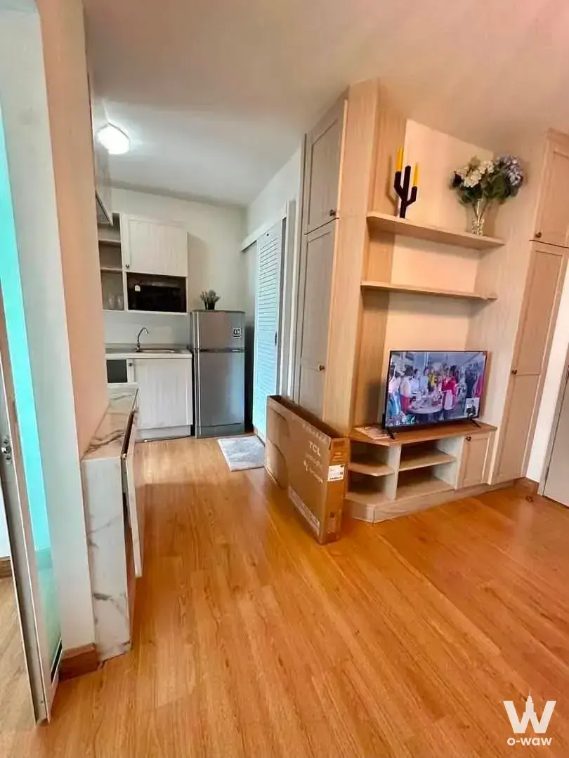 Open-plan living space in a Rat Burana 1-bed condo with light oak floors and a compact kitchenette