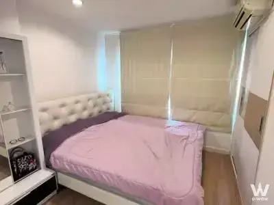 Bedroom in Lumpini Ville Ladprao-Chokchai4 condo with queen bed, pink duvet, and built-in wardrobe