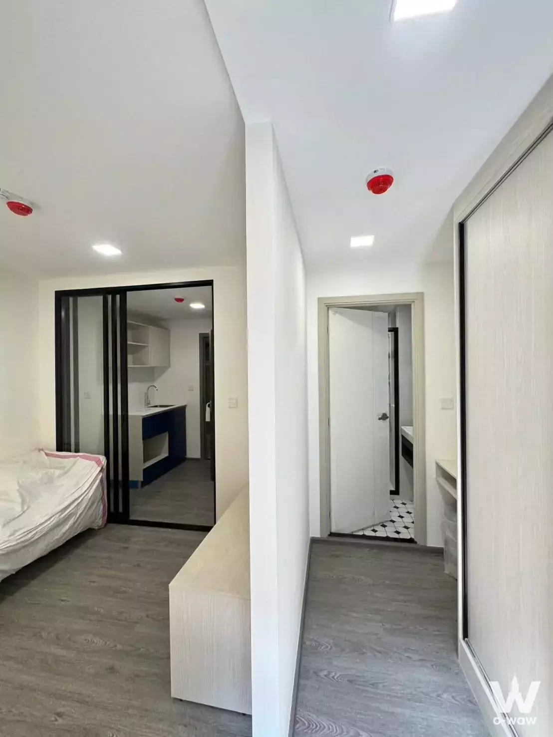 Modern corridor showing bedroom, kitchenette, and bathroom entrance in Kave Wonderland condo