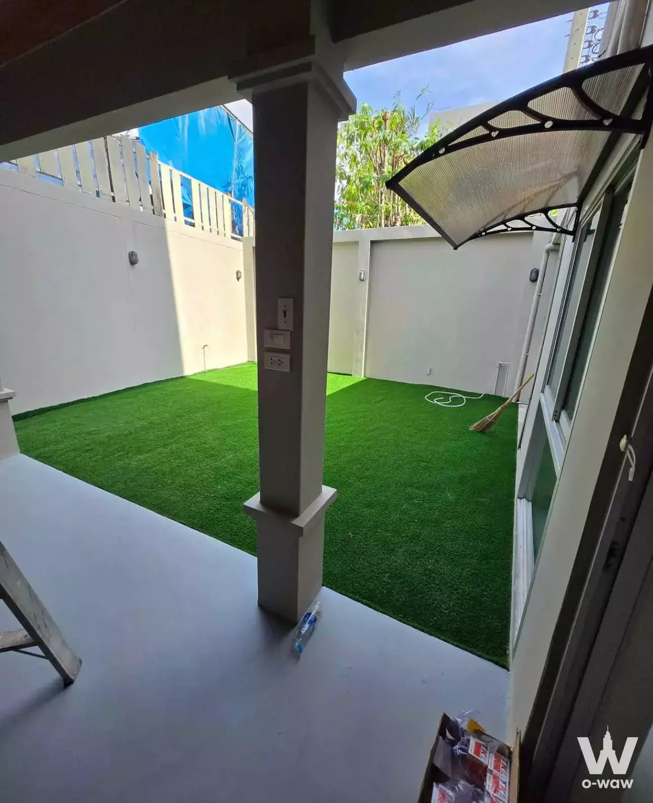 Private outdoor courtyard in a Noble Cube Pattanakarn rental with artificial turf and white privacy walls