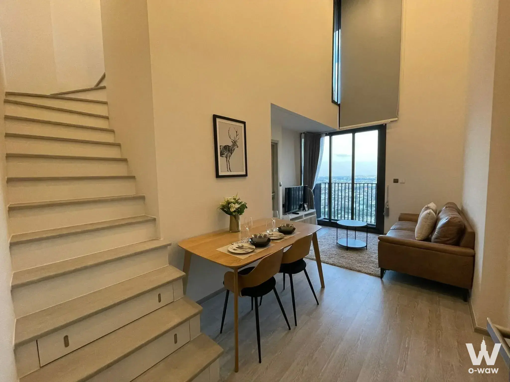 THE LINE Sukhumvit 71 1-bed condo dining area with high ceilings, light wood floors, and city skyline view