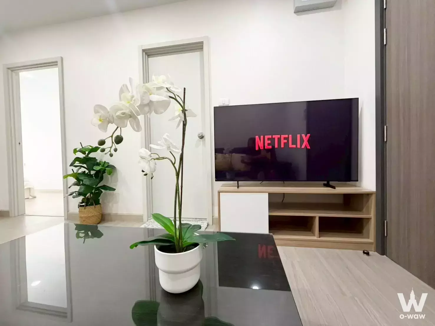 Bright 1-bed condo living room in Supalai City Resort Charan 91 with orchid and Netflix TV