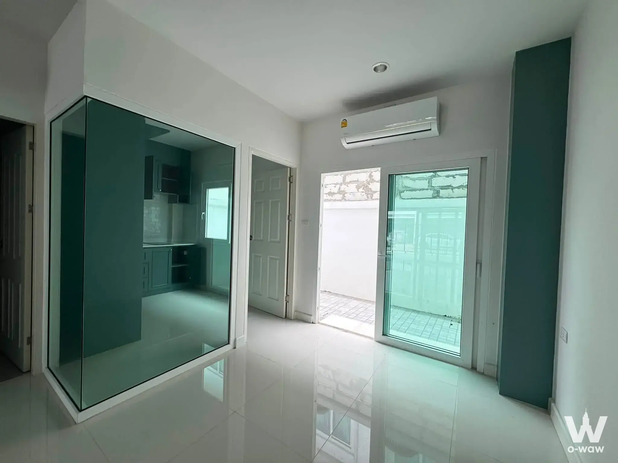 Empty living area with high-gloss tiles and glass partition in a 3-bed house for rent