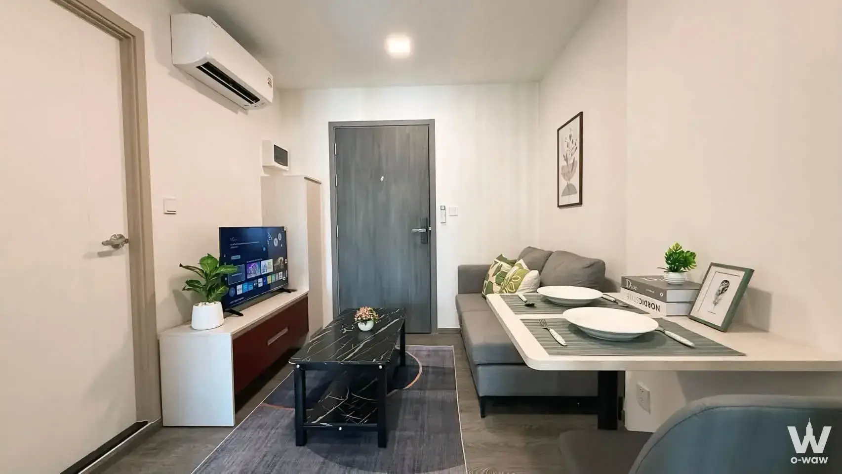 Living room in a Kave Wonderland condo with a grey sofa and attached dining table