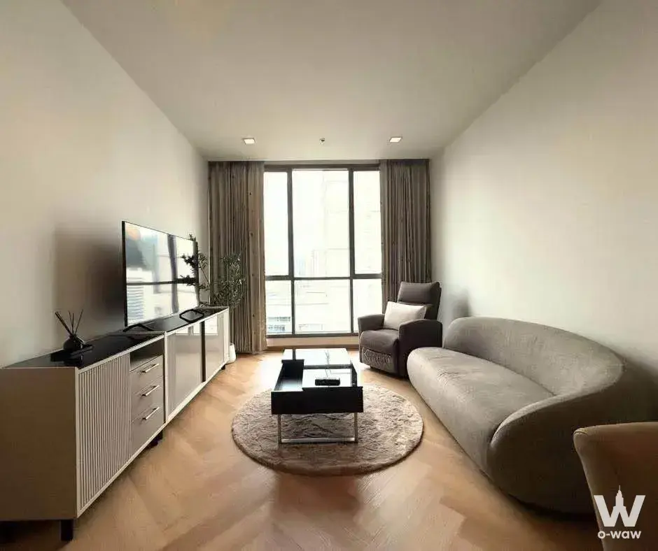 2-bed condo for rent in Hyde Sukhumvit 13 featuring curved sofa and city skyline view