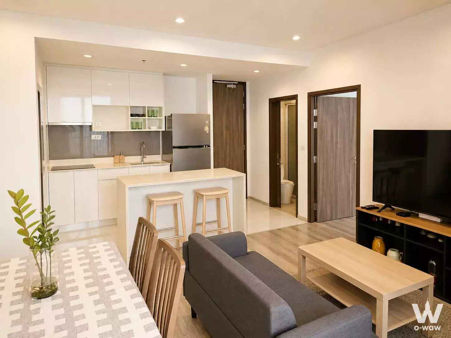 Open-plan 2-bed condo in Ideo Mobi Sukhumvit 66 with grey sofa and modern kitchenette
