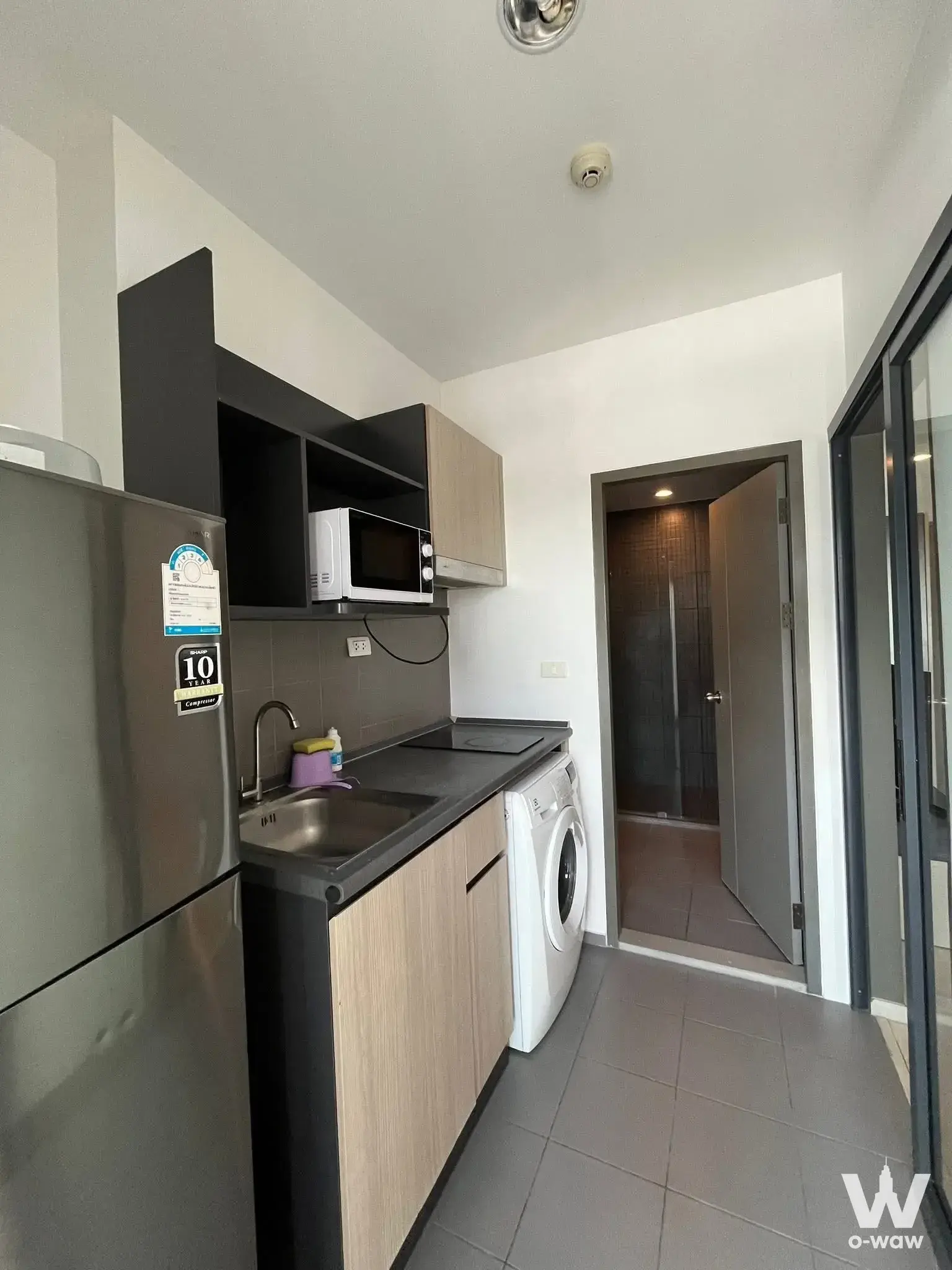 Kitchenette in IDEO Sukhumvit 115 with induction cooktop and washing machine