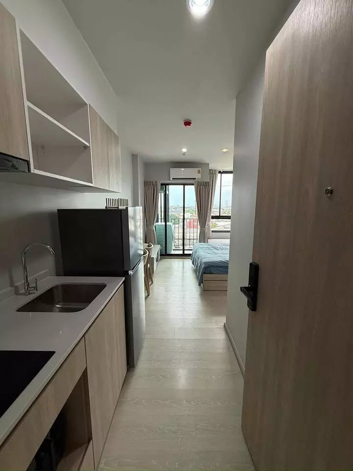 1-bed condo for rent in Nue Mega Plus Bangna with light wood flooring, kitchenette, and balcony city view