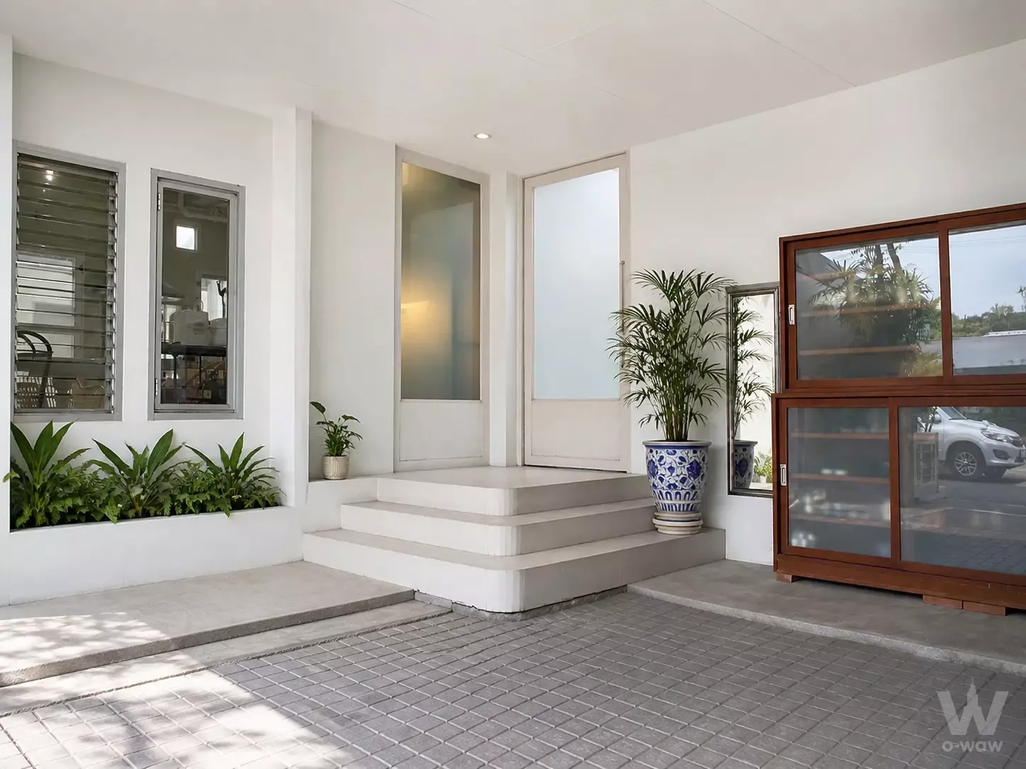 Exterior entry of NOBLE TERRA RAMA 9 condo with white steps and frosted glass doors