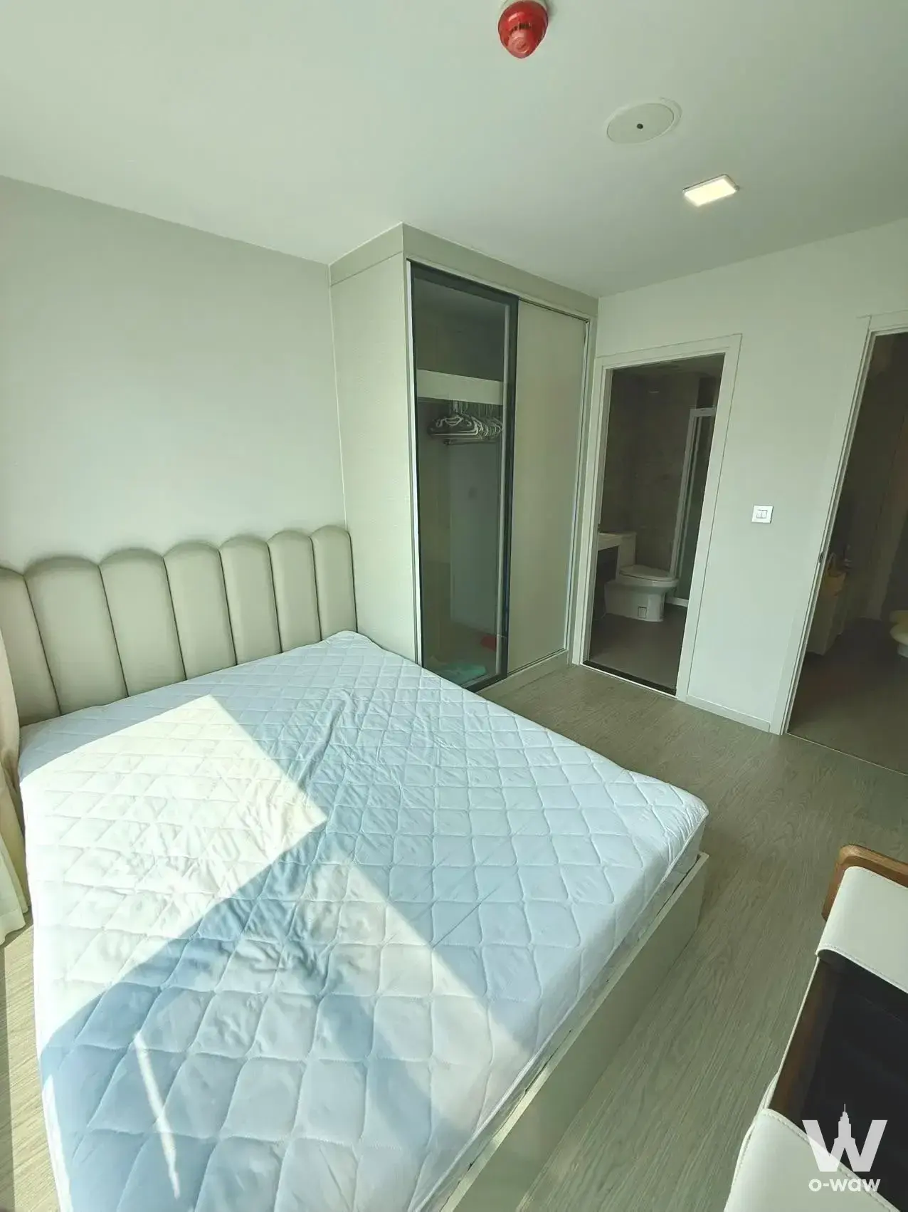 Bright bedroom in an Atmoz Oasis Onnut 1-bed condo with a cream tufted headboard, built-in wardrobe, and en-suite bathroom