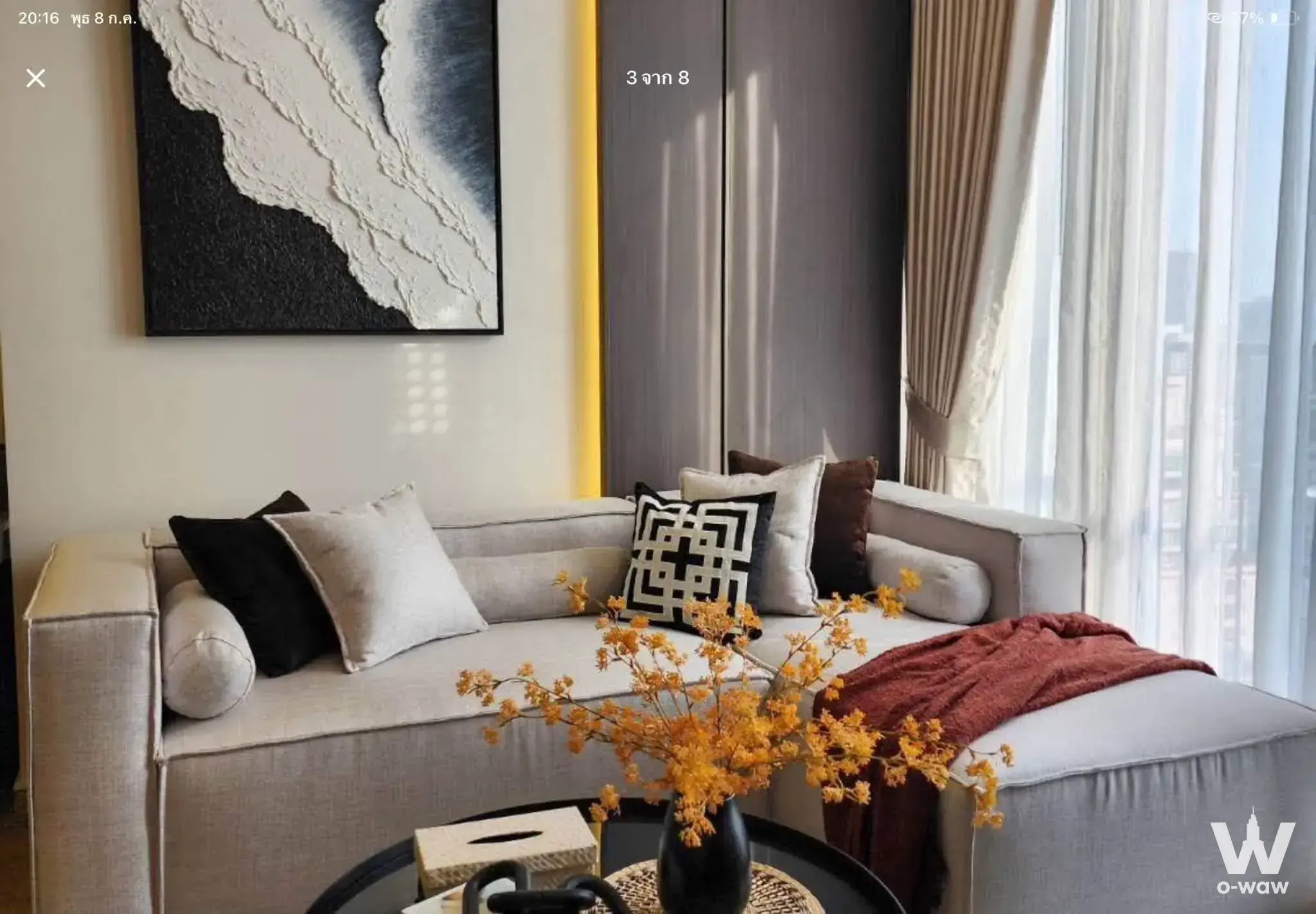Modern living area in Noble State 39 featuring grey sectional and abstract art