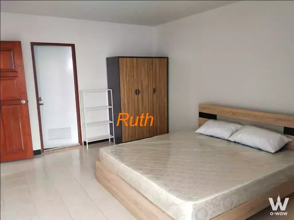 Bedroom in JC Tower with a wooden platform bed, wardrobe, and open shelving unit
