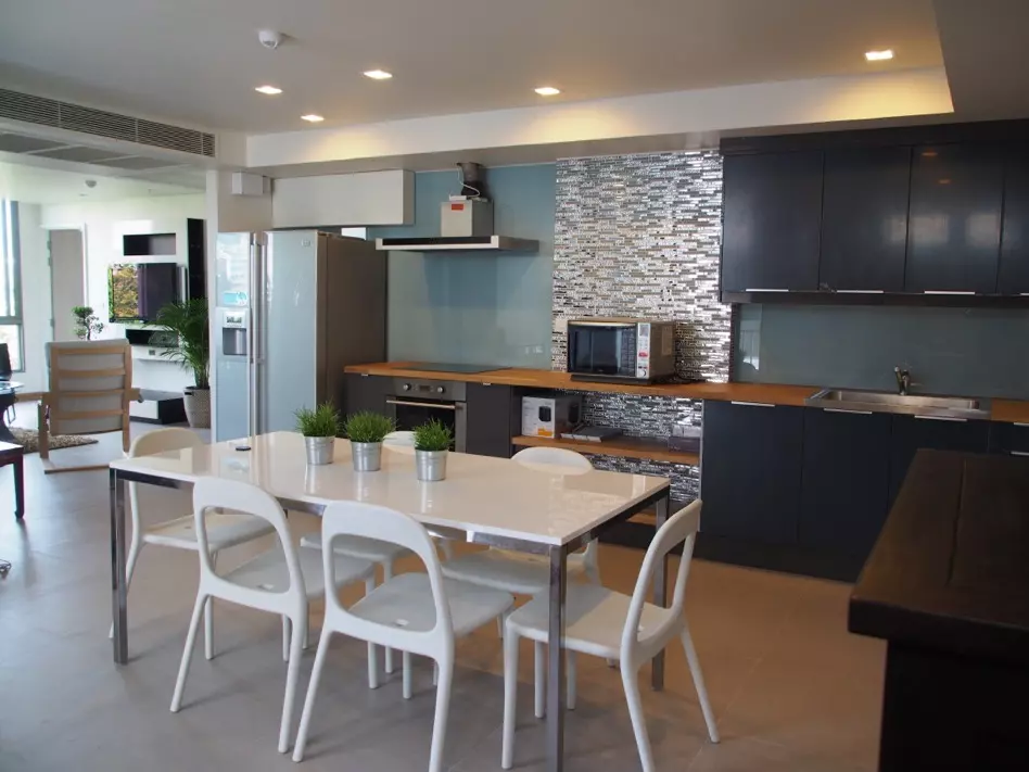 Open-plan kitchen in a 2-bed Downtown49 condo with charcoal cabinets and a quartz dining table