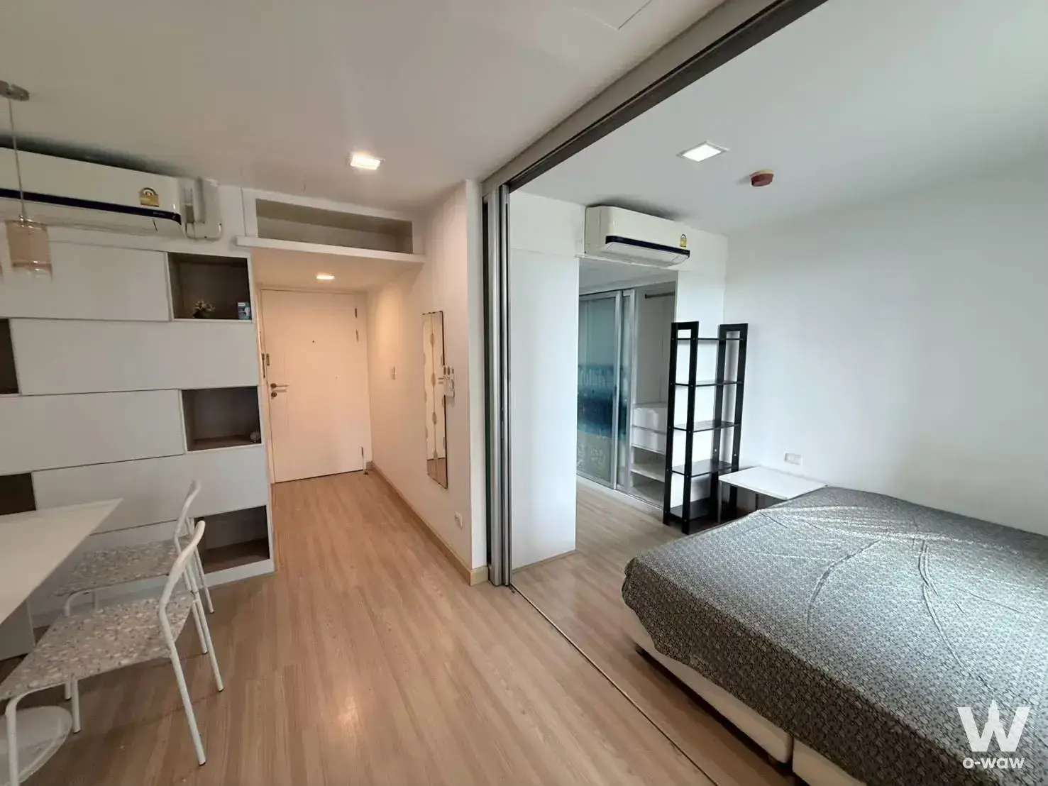 This 2-bed condo for sale has light wood floors, built-in storage, and a glass-partitioned bedroom in The Colory Vivid