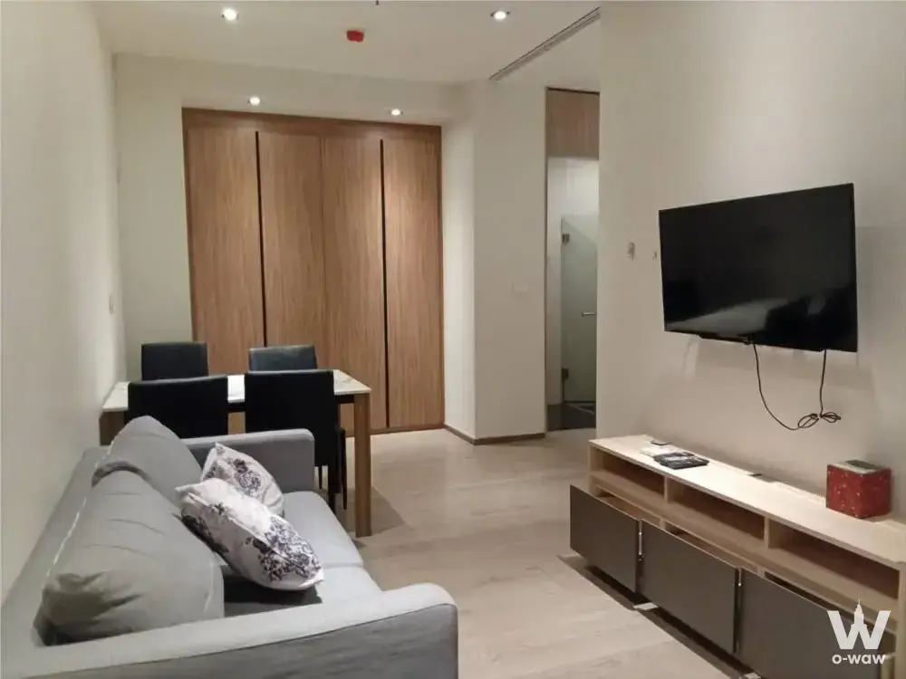 Living room in Park24 condo with grey sofa, dining set, and large wooden sliding wardrobe