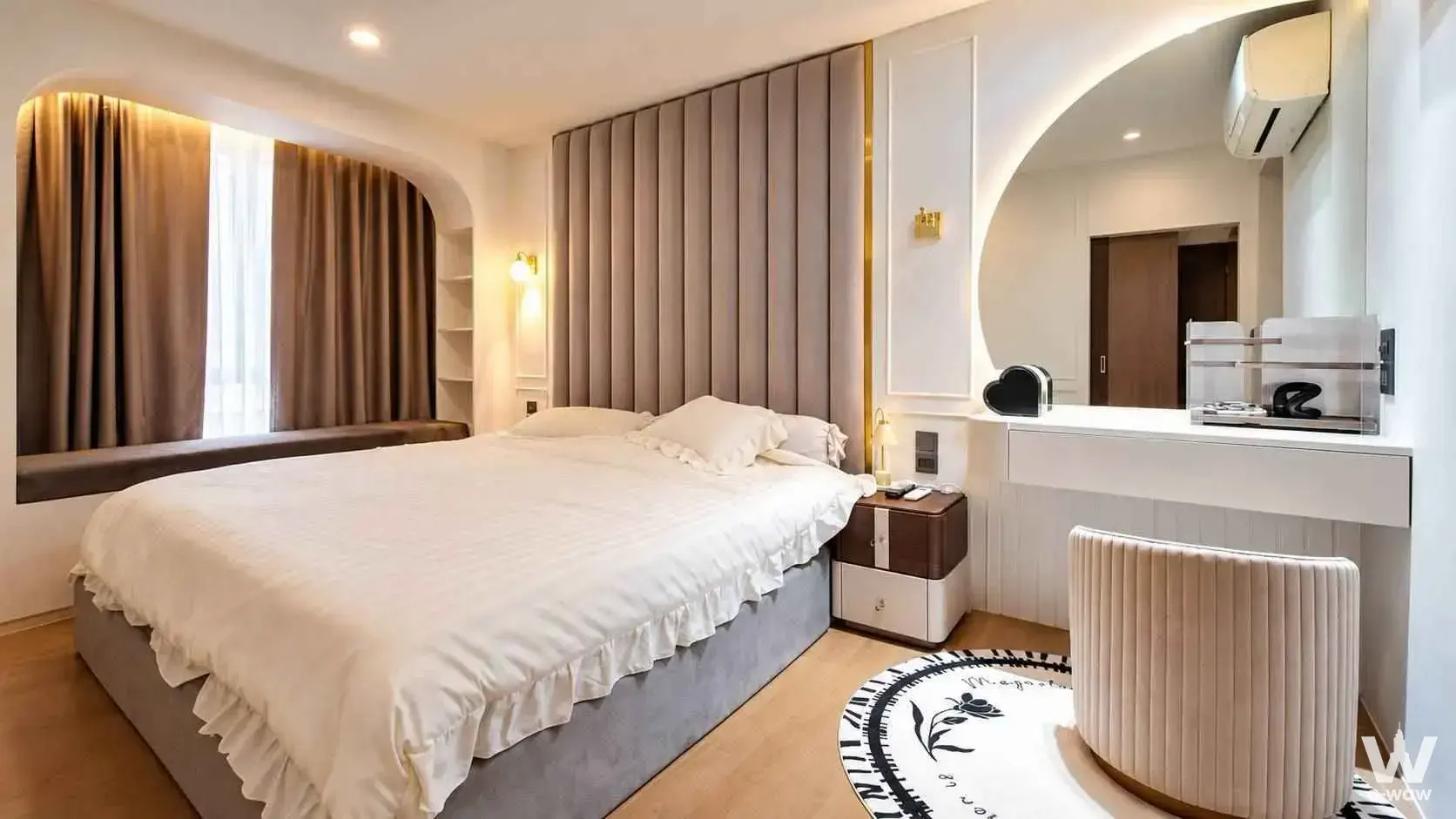 Suanbua Residence Ari bedroom with taupe tufted headboard and arched window niche