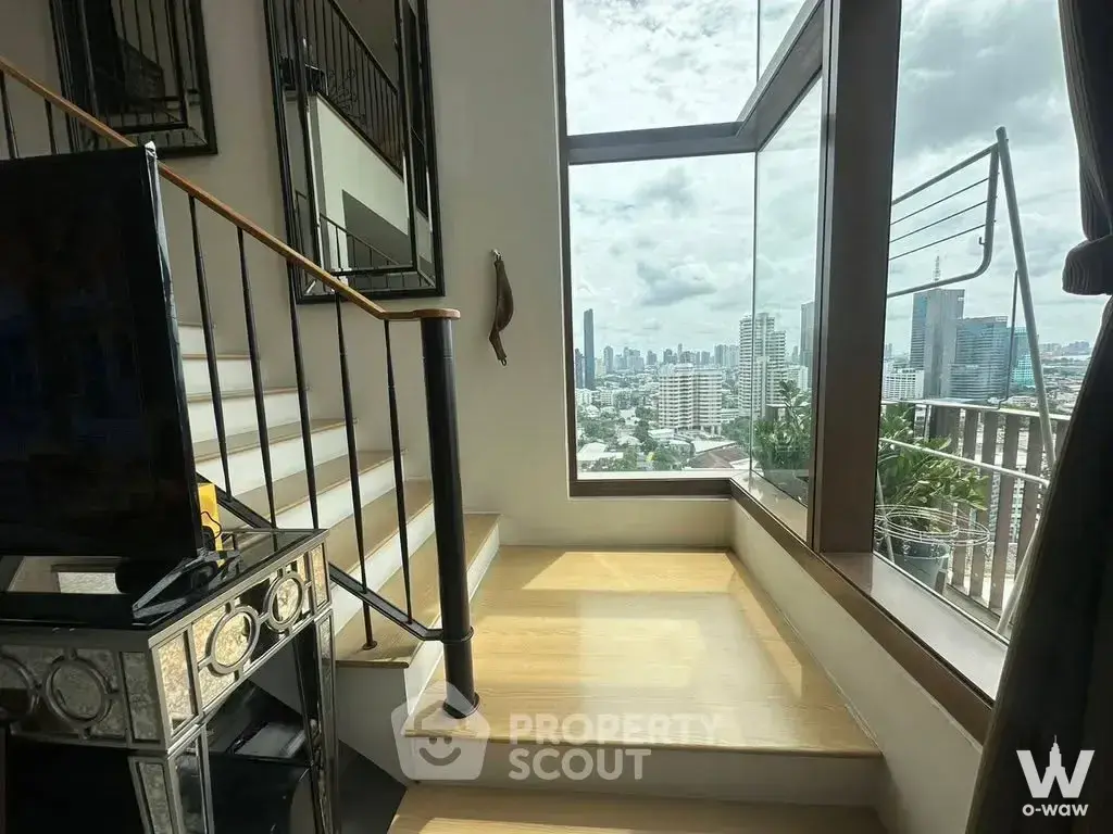 Stairwell landing in a 1-bed condo at The Emporio Place featuring light wood floors, white stairs, and floor-to-ceiling
