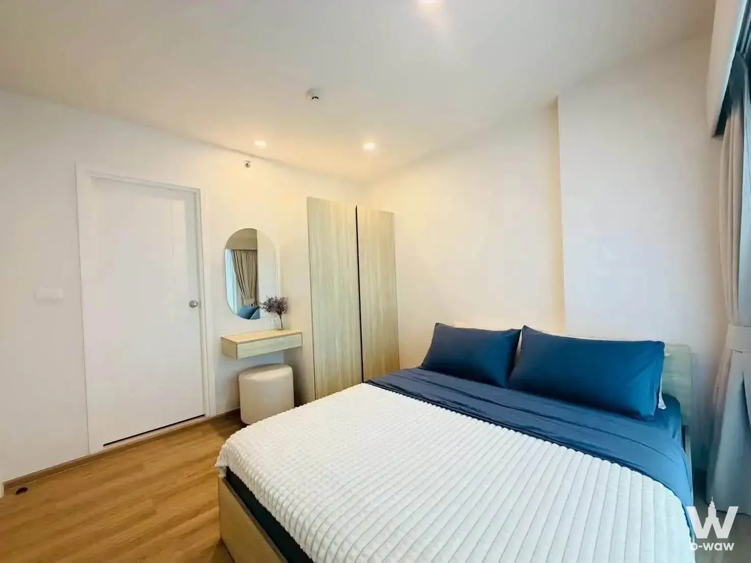 Bedroom in Phyll Phuket 1-bed condo featuring queen bed, birch wardrobe, and floating vanity