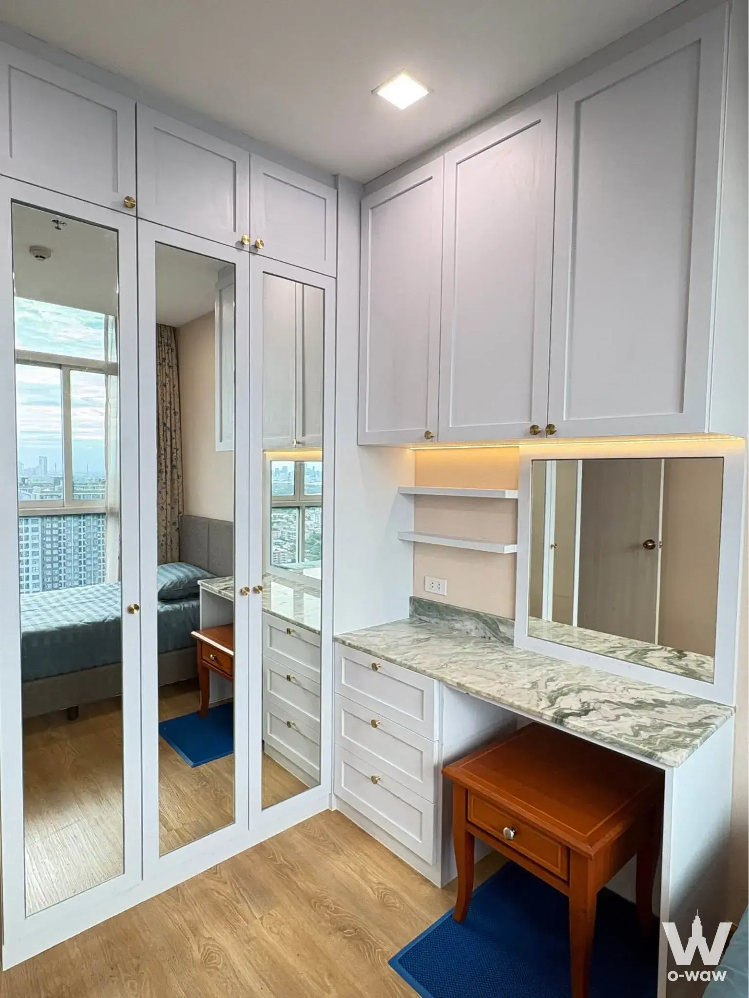 Walk-in closet in a The Coast Bangkok 2-bed condo with mirrored doors and marble vanity