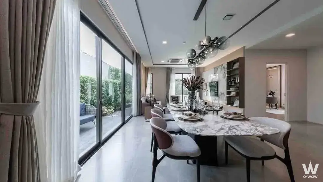 Elegant dining room featuring an oval marble table and chrome chandelier in this house for sale at Mantana Bangna Km.15