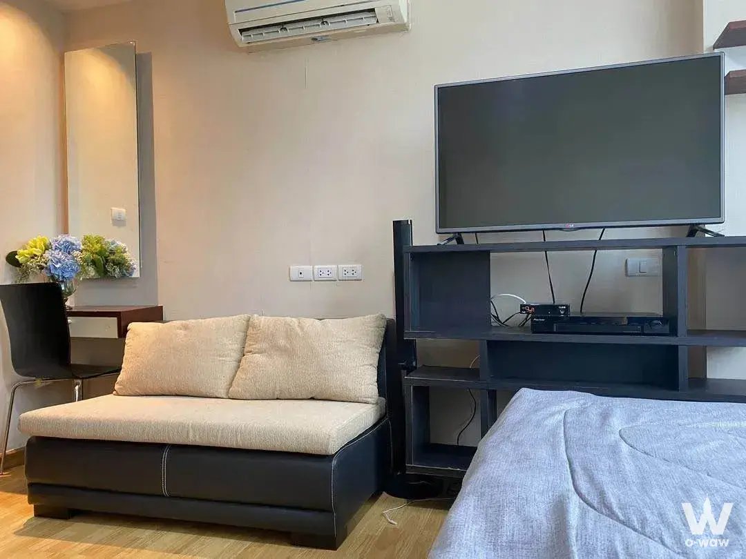 Compact studio in J.W. Boulevard Srivara with dark brown chaise lounge and open shelving