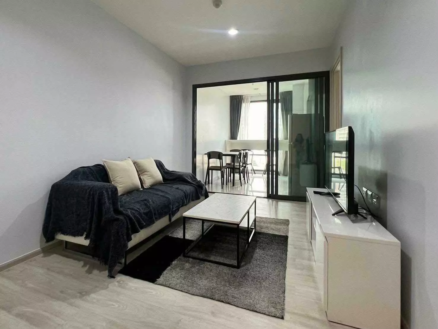 Living room in a Rhythm Sukhumvit 42 condo with cream sofa and marble coffee table