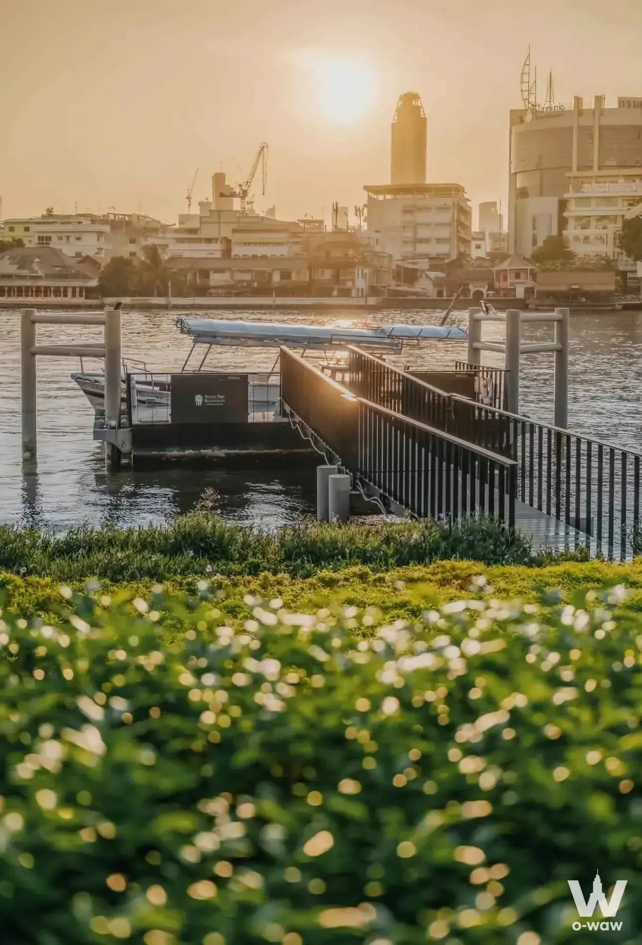 Riverside park with a longtail boat and golden sunset at Banyan Tree Residences