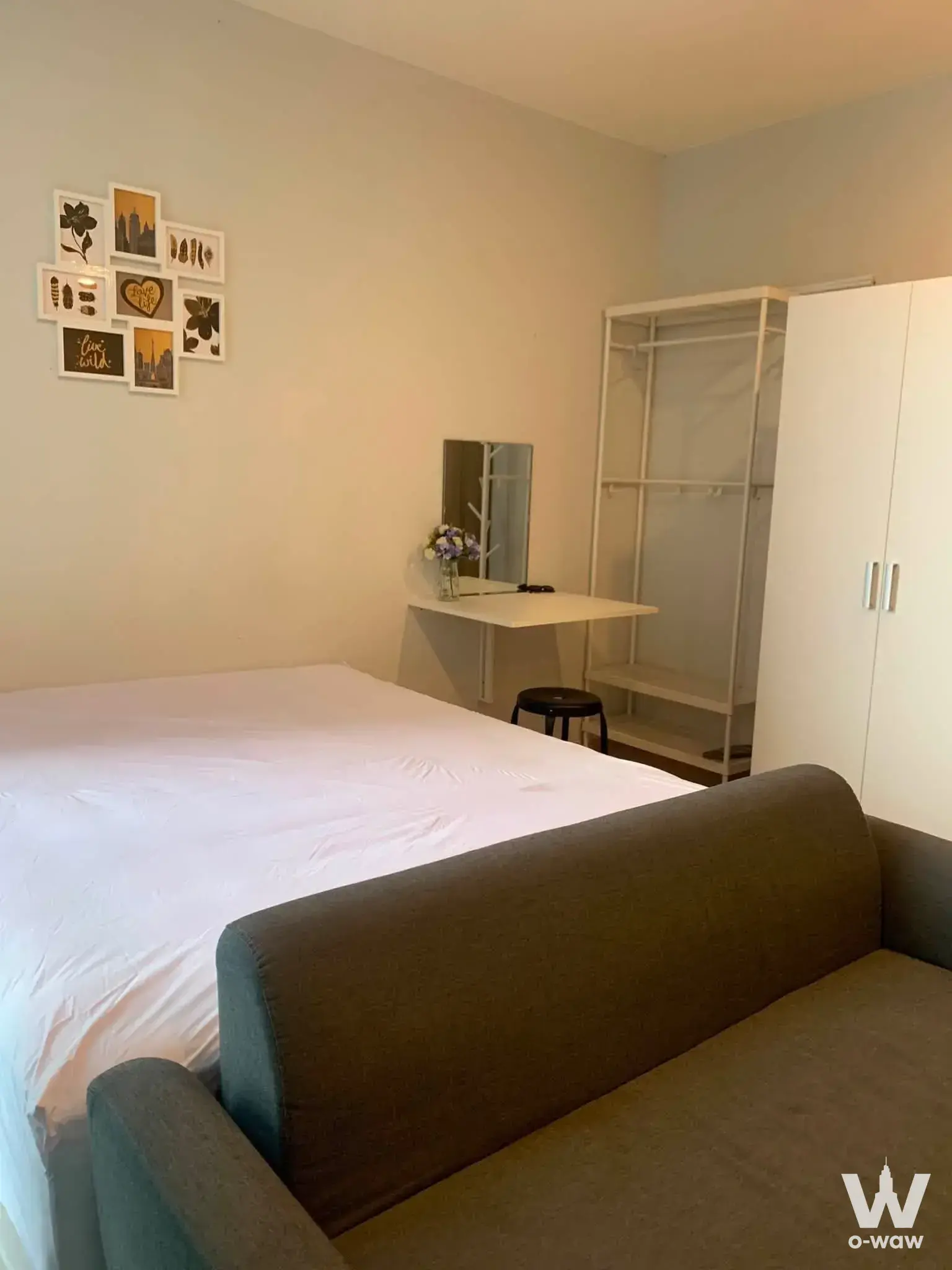 Furnished studio bedroom in Noble Revolve Ratchada 2 featuring a queen bed and grey sofa