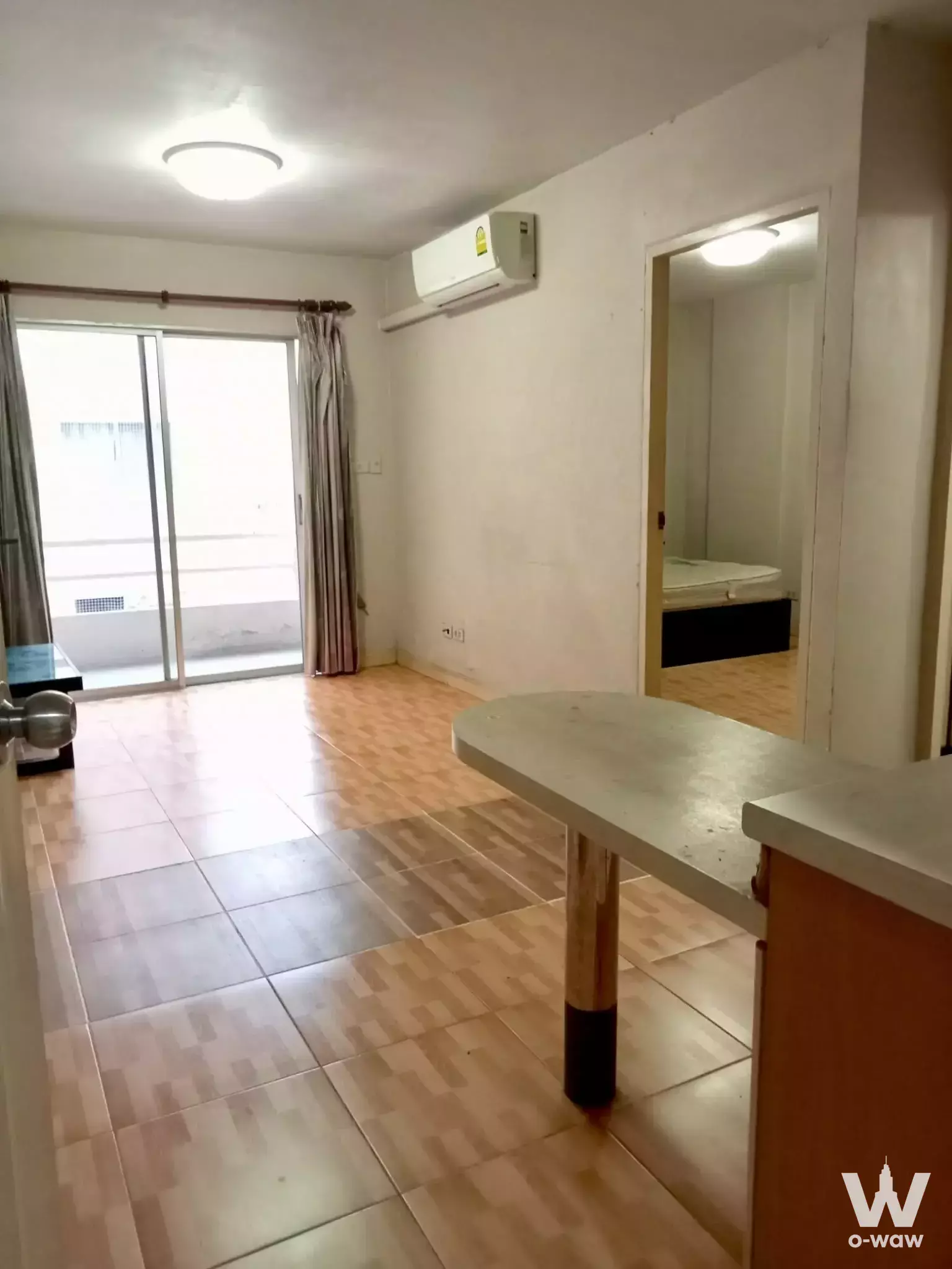 Tawanna Residence 2 1-bed condo living room with breakfast bar and balcony access