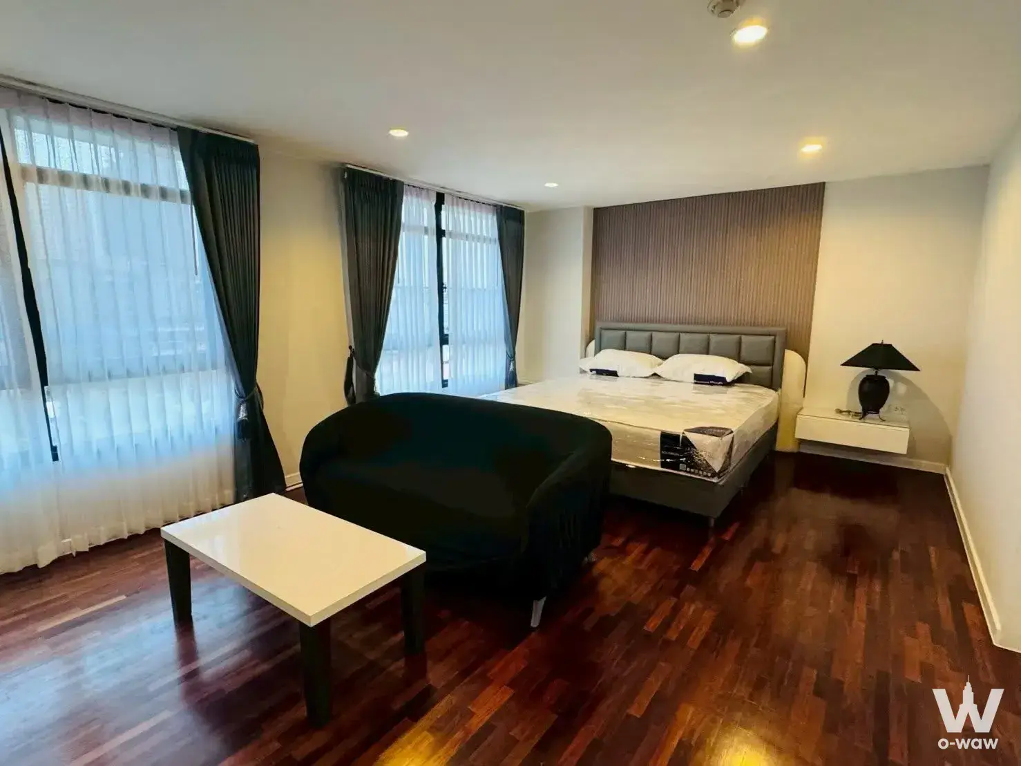 Spacious bedroom in Ban Chan Condominium featuring grey leather headboard