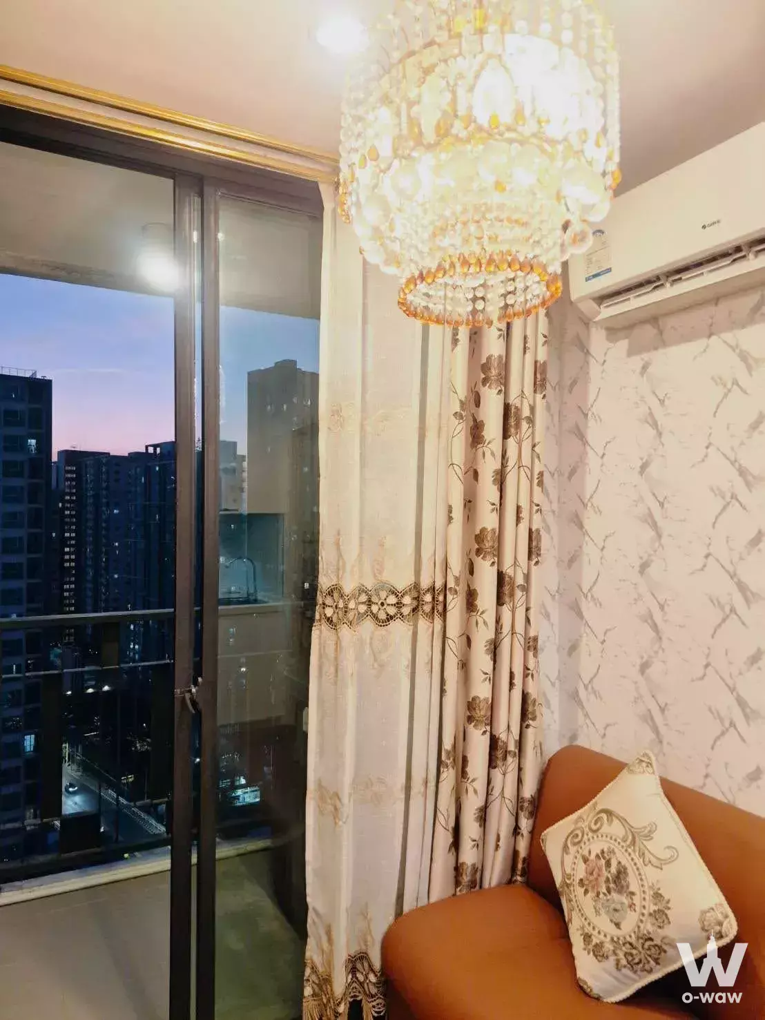 Living room in 2-bed Artemis Sukhumvit 77 condo with crystal chandelier and floor-to-ceiling city view