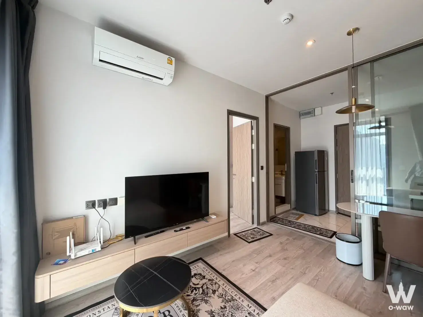 Light wood flooring and black marble coffee table in a furnished 1-bed condo for rent at Rhythm Ekkamai Estate