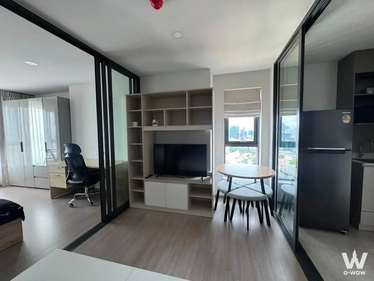 Aspire Sukhumvit-Rama 4 bedroom with black-framed glass partitions and city skyline view