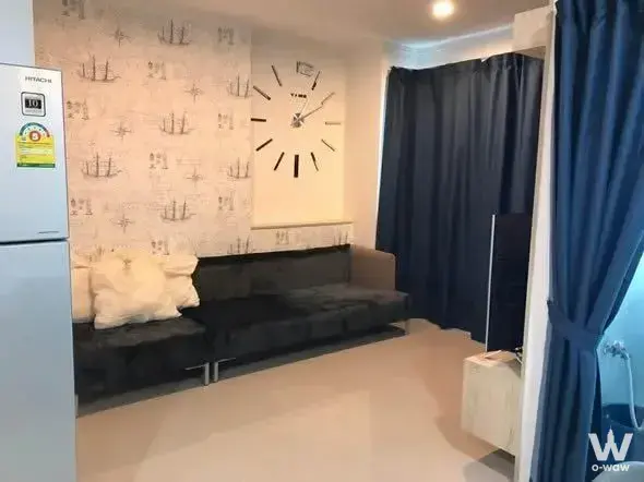 Living room in a Lumpini Park Beach Jomtien 2-bed condo with nautical wallpaper and navy drapes