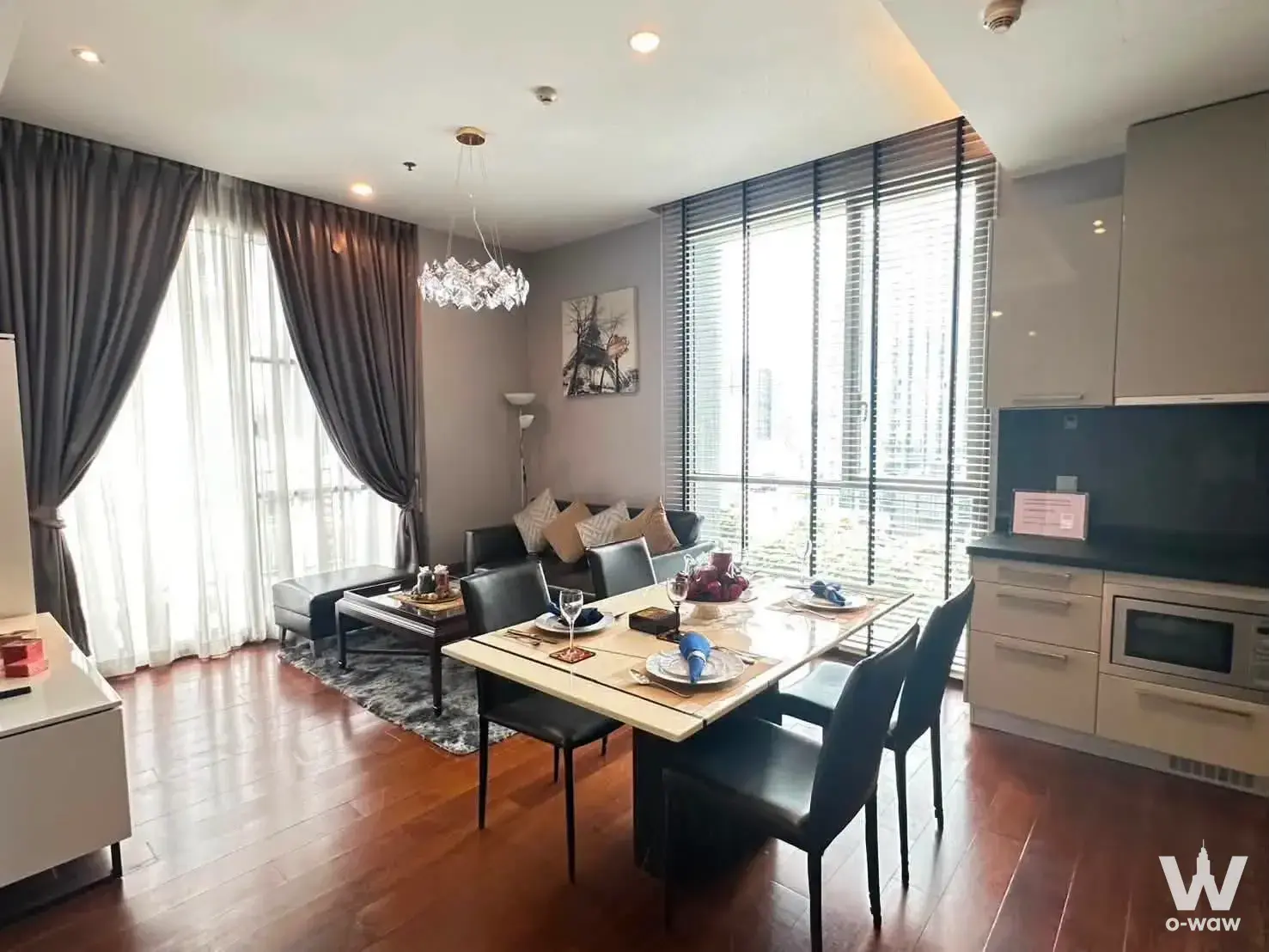 Living room in a Quattro by Sansiri condo with black leather sofa and floor-to-ceiling windows
